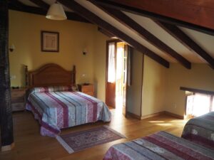 Cama matrimonial Habitación cuádruple planta bajo cubierta de la Casa Rural La Roza II